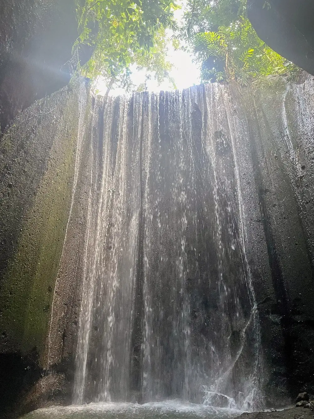 A cave waterfall, the light beam hits around 10am — Tukad Cepung, Where to ride from Sidemen